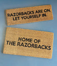 Load image into Gallery viewer, Two doormats with Razorbacks are on let yourself in text in a razorback store in Fayetteville, arkansas, razorback door mat, arkansas door mat, razorback welcome mat, Arkansas razorback door mat, razorback front door mat