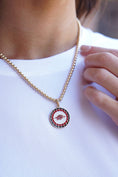 Load image into Gallery viewer, Necklace with a circular pendant featuring a red and black design on a white shirt. Razorback jewelry, razorback jewelry near me, razorback jewelry and accessories, Arkansas razorback jewelry, razorback charms for jewelry, razorback jewelry for sale, women razorback jewelry, Arkansas razorback pendant