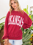 Load image into Gallery viewer, Woman wearing a red 'ARKANSAS' sweater with plants in the background, Arkansas razorback sweatshirt, Arkansas razorback sweatshirt women’s, Arkansas ribbed sweatshirt, Arkansas razorback apparel near me, Arkansas razorback store near me