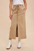 Load image into Gallery viewer, Person wearing tan wide-leg pants with a white top and white boots on a beige background