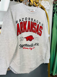 Load image into Gallery viewer, Gray sweatshirt with 'Razorbacks Arkansas' text and logo on a hanger. gray Razorback sweatshirt, Pressbox Arkansas sweatshirt, gray Arkansas sweatshirt, razorback shirts, Arkansas shirts, AR Razorback apparel, Razorback stores Fayetteville ar shopping