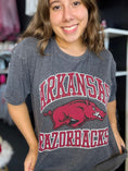 Load image into Gallery viewer, Person wearing a gray 'Arkansas Razorbacks' t-shirt with a red logo, grey Arkansas razorback tee, Arkansas razorback shirts, arkansas razorback boutique clothing, arkansas razorback shirts, razorback store, razorback apparel Fayetteville ar, arkansas razorback store