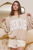 Load image into Gallery viewer, Woman wearing a beige sweater with 'JOHN 3:16' text in a decorative room.
