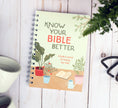 Load image into Gallery viewer, Notebook titled 'Know Your Bible Better' on a wooden surface with a plant and mug in the background.