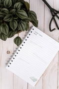Load image into Gallery viewer, Notebook with a plant on a wooden surface