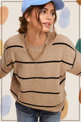 Load image into Gallery viewer, Woman wearing a beige sweater with black stripes, blue jeans, and a blue cap against a polka dot background. Clothing stores Fayetteville ar, la miel clothing, women’s sweaters, Whimsy woo