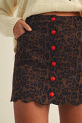 Load image into Gallery viewer, Leopard print skirt with red buttons worn by a woman in a Fayetteville ar boutique store, leopard skirt, leopard button up skirt, leopard mini skirt, holiday skirt, holiday leopard skirt