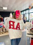Load image into Gallery viewer, Person wearing a white sweatshirt with red Arkansas letters in a Fayetteville ar boutiques, Arkansas shirt, arkansans sweatshirt, razorback shirt, Razorback Sweatshirt, clothing stores Fayetteville ar