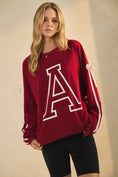 Load image into Gallery viewer, Woman wearing a red sweatshirt with a large white letter 'A' on a beige background, arkansas sweatshirt, A sweatshirt, arkansas sweatshirt women, arkansas sweatshirt near me, arkansas sweatshirt nearby, embroidered arkansas sweatshirt, university of arkansas crewneck