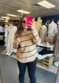 Load image into Gallery viewer, Woman taking a mirror selfie wearing a beige sweater with black stripes in a clothing store Fayetteville ar, sweater, sweaters for women, sweater nearby, Fayetteville ar clothing stores
