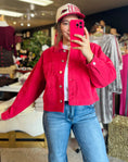 Load image into Gallery viewer, A woman taking a mirror selfie wearing a red Charming Stitch Arkansas embroidery twill jacket, a top choice for Arkansas Razorback shirts for women at our Fayetteville boutique.