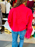 Load image into Gallery viewer, Back view of the red Charming Stitch jacket showing the large "Arkansas Razorbacks" tonal embroidery, styled with flare jeans from a leading boutique in Arkansas.