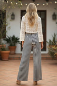 Load image into Gallery viewer, black and white vertical striped wide-leg pants styled for a chic, everyday boutique look.