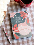 Load image into Gallery viewer, A spiral-bound journal with a multicolored floral design on the cover, titled 'Taking Your Time Through the Bible Journal', displayed on a table with a cup of coffee and a pen. Taking your time through the Bible journal, bible study journal, journey journal, christian journal