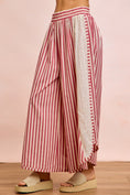 Load image into Gallery viewer, Side profile of the Free Spirit red stripe pants highlighting the relaxed barrel leg fit and soft cotton-poly blend fabric.