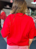 Load image into Gallery viewer, A detailed shot of the high-quality, thick knit fabric on the front of the red oversized gameday sweater. You’ll find this and other red gameday outfits at Whimsy Whoo Botuique store in Fayetteville, Akansas