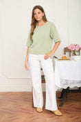 Load image into Gallery viewer, Full front view of the sage green Meet Me in the Meadow Box Knit Sweater. This raw-edge, short-sleeve pullover is an elevated staple from Whimsy Boutique, the best boutique in Fayetteville.