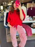 Load image into Gallery viewer, Person wearing a red top and red and white striped pants taking a mirror selfie in a boutiques in Fayetteville, AR.