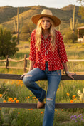 Load image into Gallery viewer, The Dot-to-Dot Red Woven Top, a red and white polka dot button-down blouse with a peplum hem, styled with denim shorts and a western hat.