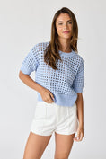 Load image into Gallery viewer, Front view of the Oh Hey Crochet! open-knit cropped sweater in Sky Blue, paired with high-waisted white shorts at Whimsy Whoo Boutique