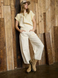 Load image into Gallery viewer, Ecru barrel jean overalls at Whimsy Whoo, a local Fayetteville boutique, styled for a trendy boho spring look.