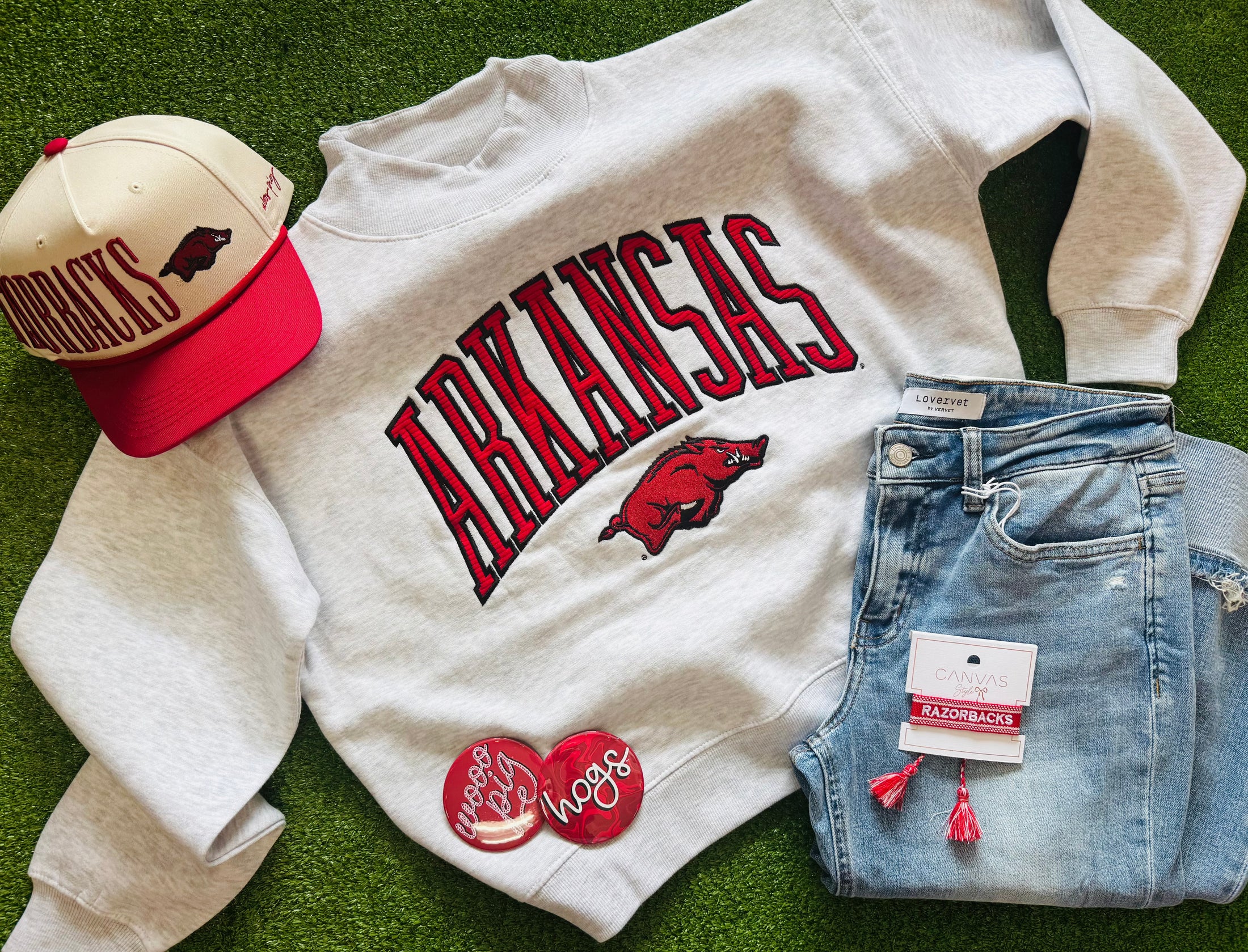 Arkansas-themed sweatshirt, cap, and jeans on a grassy background, Arkansas mock neck sweatshirt, Arkansas mock neck, arknasas razorback women’s clothing, arknasas razorback boutique clothing, university of Arkansas clothing, H&M