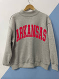 Load image into Gallery viewer, Arkansas-themed sweatshirt, cap, and jeans on a grassy background, Arkansas mock neck sweatshirt, Arkansas mock neck, arknasas razorback women’s clothing, arknasas razorback boutique clothing, university of Arkansas clothing, H&M
