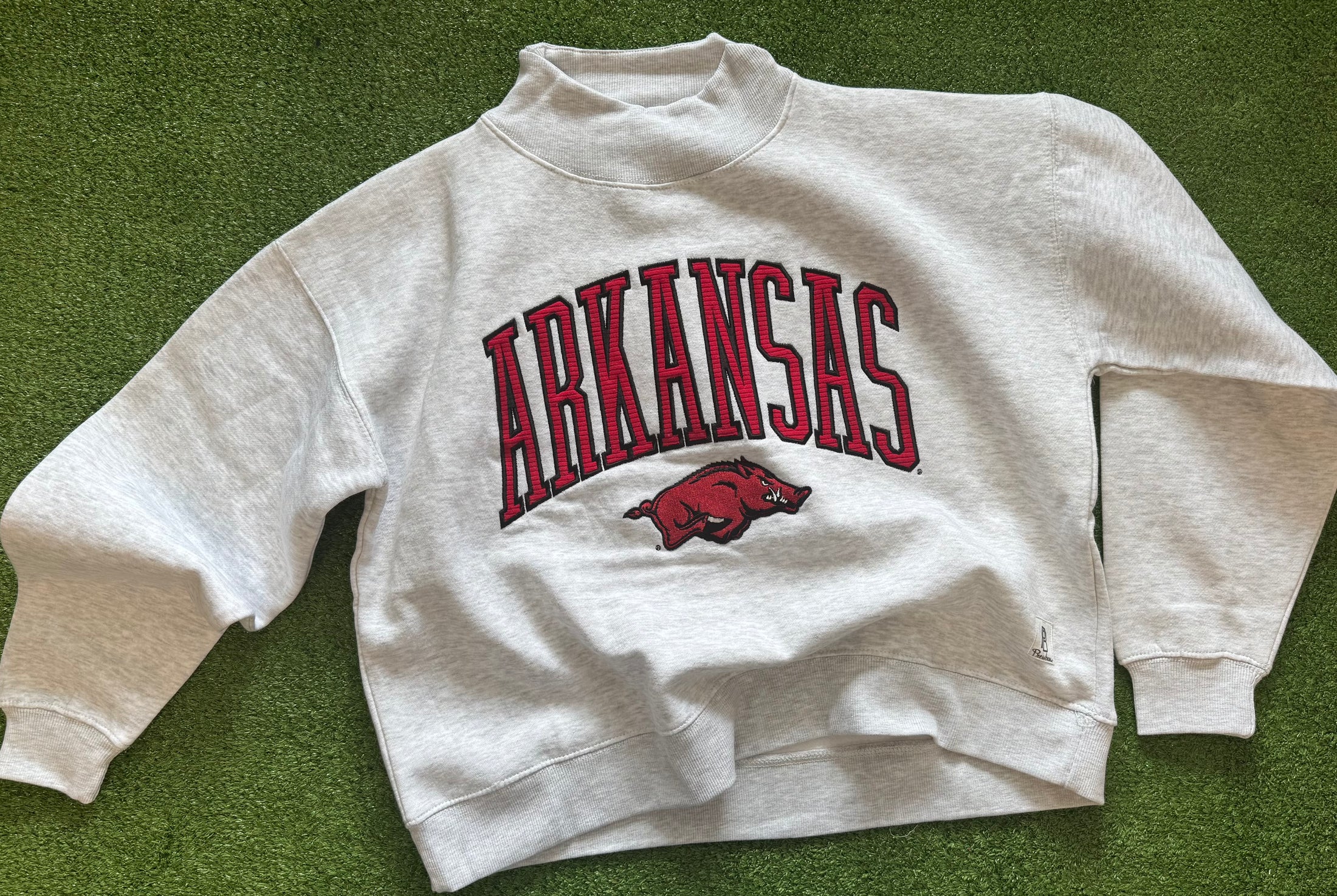 Gray sweatshirt with 'ARKANSAS' and a razorback on a green background in a Fayetteville ar clothing stores, Arkansas mock neck sweatshirt, Arkansas mock neck, arknasas razorback women’s clothing, arknasas razorback boutique clothing, university of Arkansas clothing, H&M