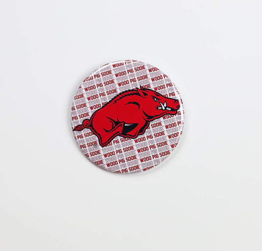 Red and white button with a graphic of a razorback and 'Wood Pig sooie' text on a white background, gameday buttons near me, Hog Heaven store, boutiques near springdale, ar