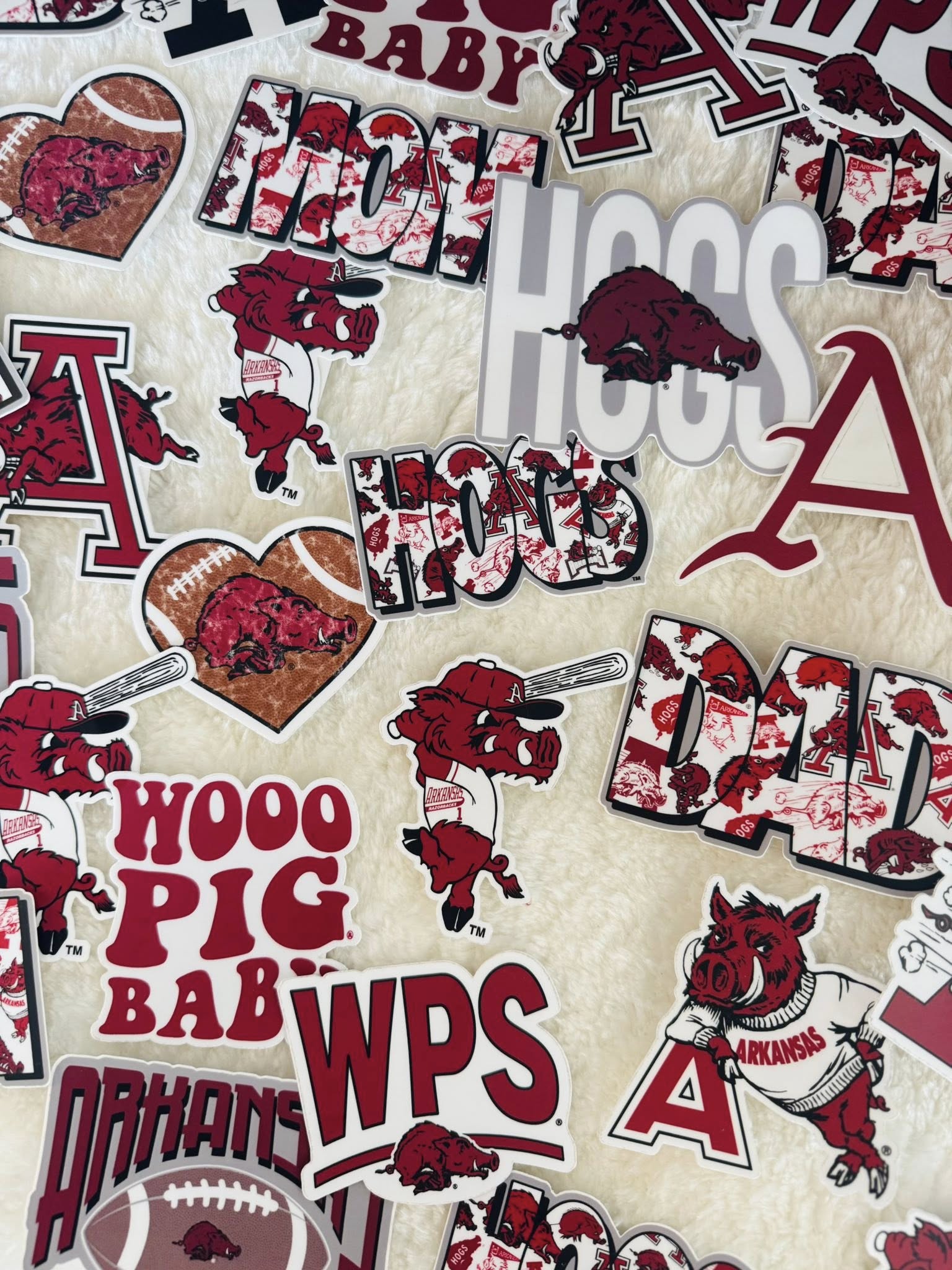 Collection of Arkansas Razorbacks-themed stickers with logos and text on a beige background. Arkansas razorback stickers, razorback stickers, arkansas stickers near me, razorback store Fayetteville ar
