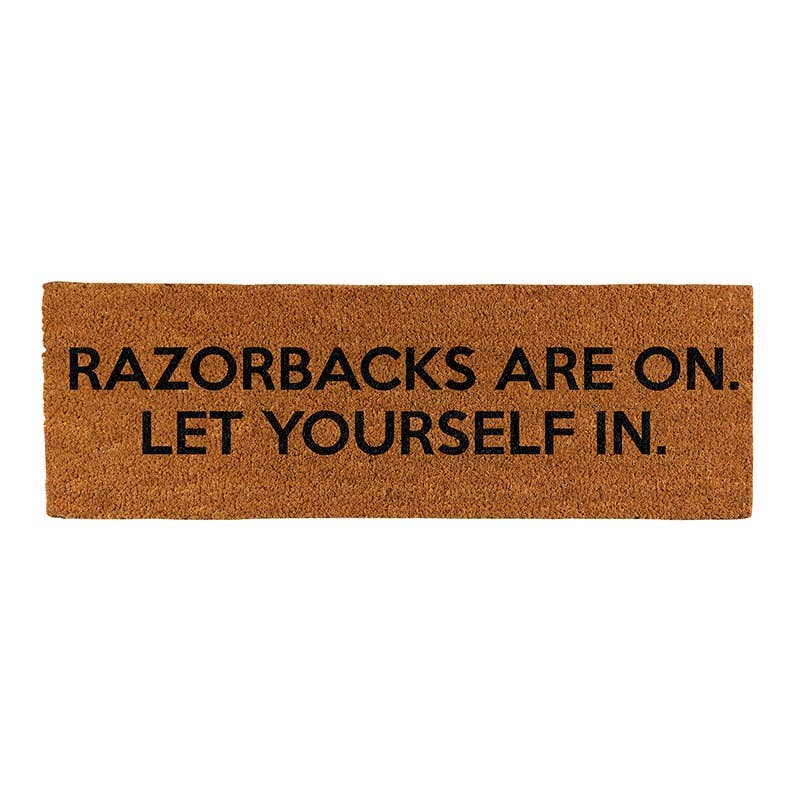 Doormat with text 'RAZORBACKS ARE ON. LET YOURSELF IN.' on a white background