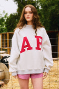 Load image into Gallery viewer, Person wearing a white sweatshirt with red letters 'AR' and checkered shorts outdoors. Arkansas reversible sweatshirt, razorback reversible sweater, Arkansas reversible shirt, Arkansas reversible shirt women’s, razorback store Fayetteville ar, Fayetteville boutiques, shopping near me, boutiques in the NWA mall
