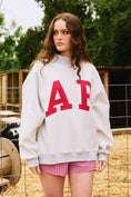 Load image into Gallery viewer, Person wearing a white sweatshirt with red letters and pink shorts in an outdoor setting Arkansas reversible sweatshirt, razorback reversible sweater, Arkansas reversible shirt, Arkansas reversible shirt women’s, razorback store Fayetteville ar, Fayetteville boutiques, shopping near me, boutiques in the NWA mall
