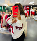 Load image into Gallery viewer, Person taking a mirror selfie in a store with a red phone, wearing a white and red jacket. Arkansas Razorback sweatshirt,  Arkansas sweatshirt vintage, Arkansas razorback sweatshirt vintage, razorback store near me, Arkansas razorback apparel
