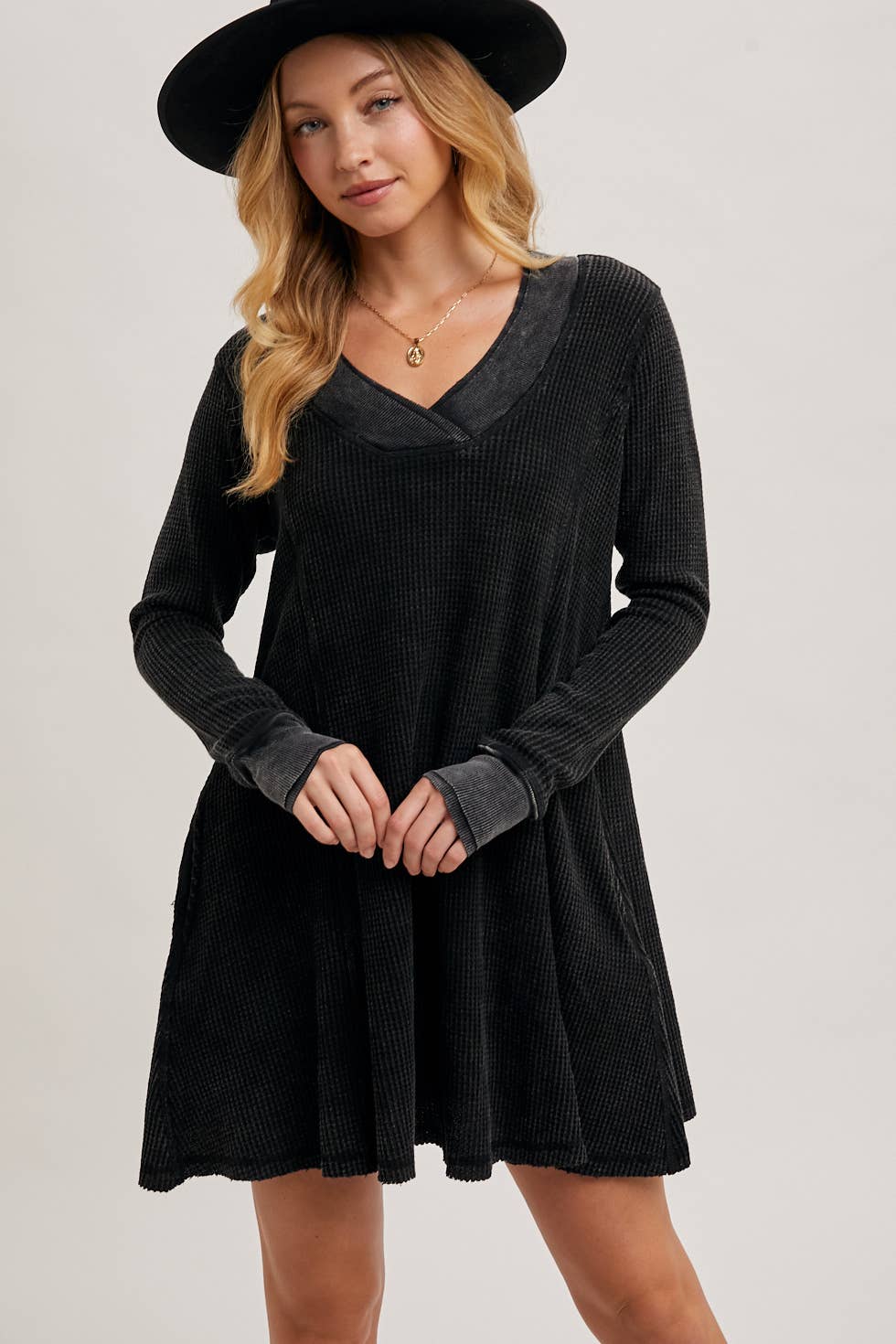 Woman wearing a black dress with long sleeves and a black hat on a plain background, thermal knit dress, waffle knit dress with sleeves, Fayetteville boutiques, clothing stores in Fayetteville ar