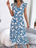 Load image into Gallery viewer, A model wearing a blue and white floral maxi dress with a V-neck and elastic high waist. Clothing stores
