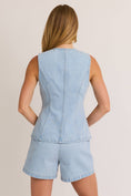 Load image into Gallery viewer, Woman wearing a light blue denim romper on a plain background, women’s denim vest, women’s denim top, women’s sleeveless top, clothing stores, Fayetteville ar clothing store

