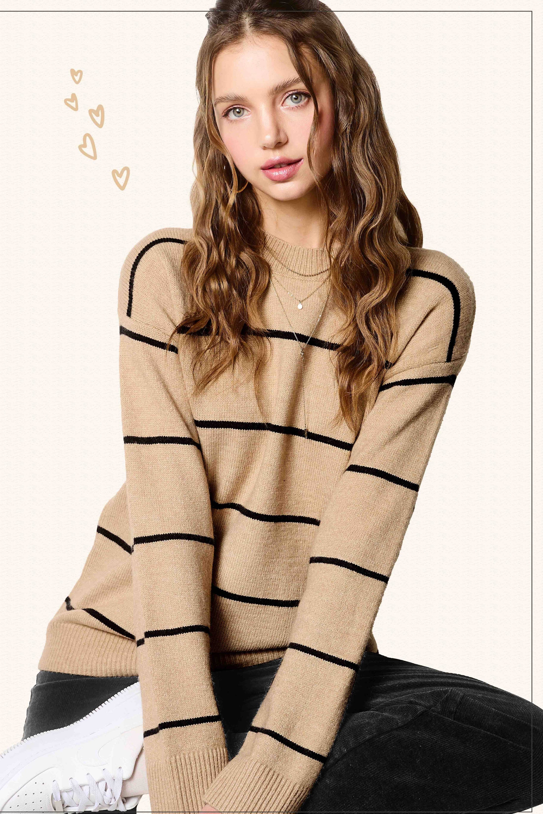 Woman wearing a beige sweater with black stripes on a white background, women’s sweaters near me, clothing stores Fayetteville ar