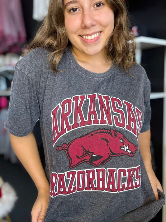 Person wearing a gray 'Arkansas Razorbacks' t-shirt with a red logo, grey Arkansas razorback tee, Arkansas razorback shirts, arkansas razorback boutique clothing, arkansas razorback shirts, razorback store, razorback apparel Fayetteville ar, arkansas razorback store