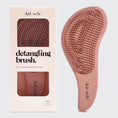 Load image into Gallery viewer, A terracotta-colored detangling brush with flexible bristles, displayed next to its packaging which has kitsch brand name and product description, kitsch hair, kitsch hair brush, kitsch hair products
