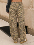 Load image into Gallery viewer, Wide-leg leopard print pants in beige and brown, shown on a woman from a Fayetteville boutique: Whimsy Whoo boutique store.
