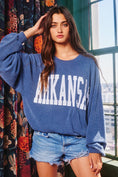Load image into Gallery viewer, Woman wearing a blue 'ARKANSAS' sweatshirt with colorful curtains and a window in the background, arkansas sweatshirt, A sweatshirt, arkansas sweatshirt women, arkansas sweatshirt near me, arkansas sweatshirt nearby, embroidered arkansas sweatshirt, university of arkansas crewneck, navy Arkansas shirt, navy arkansas swearshirt
