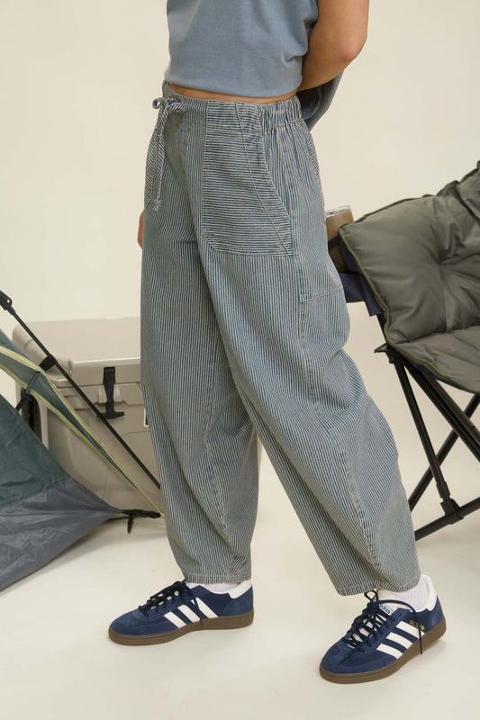 Person wearing gray checkered pants and blue Adidas sneakers in a minimal indoor setting. navy parachute pants, parachute pants 80s, parachute pants women, parachute pants h&m, parachute pants 90s, parachute pants near me, parachute pants my hammer, barrel pants, barrel leg pants, barrel jeans barrel pants trousers, barrel jeans women, barrel pants anthropology