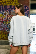 Load image into Gallery viewer, Woman wearing an oversized gray Arkansas sweatshirt styled for Razorback football game day in FAyetteville. 
