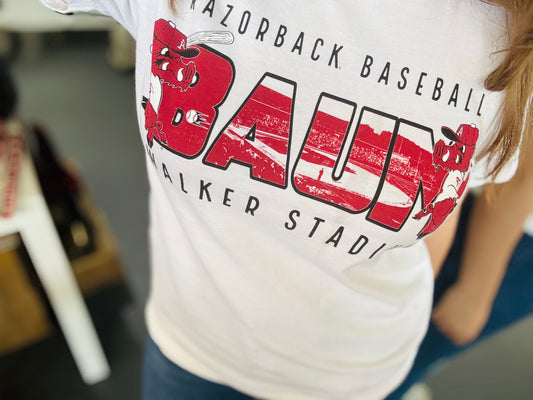 White t-shirt with red and black Baum graphics and text, worn by a person, razorback baseball tee, razorback baseball shirt, razorback baseball shirt, shopping in Fayetteville ar razorback shoppe