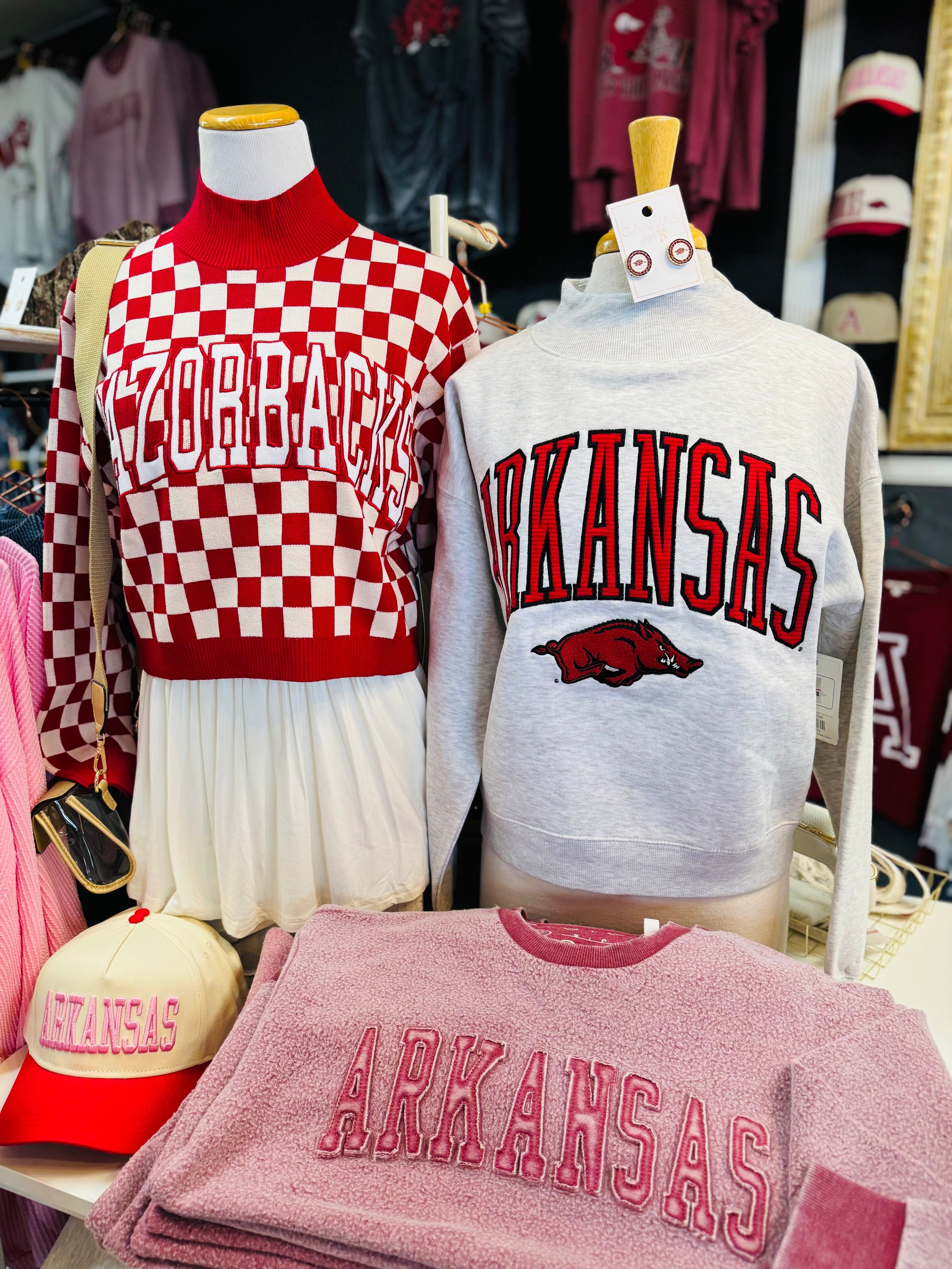 Arkansas-themed clothing and accessories on mannequins with 'ARKANSAS ' text in a Fayetteville Arkansas razorback store