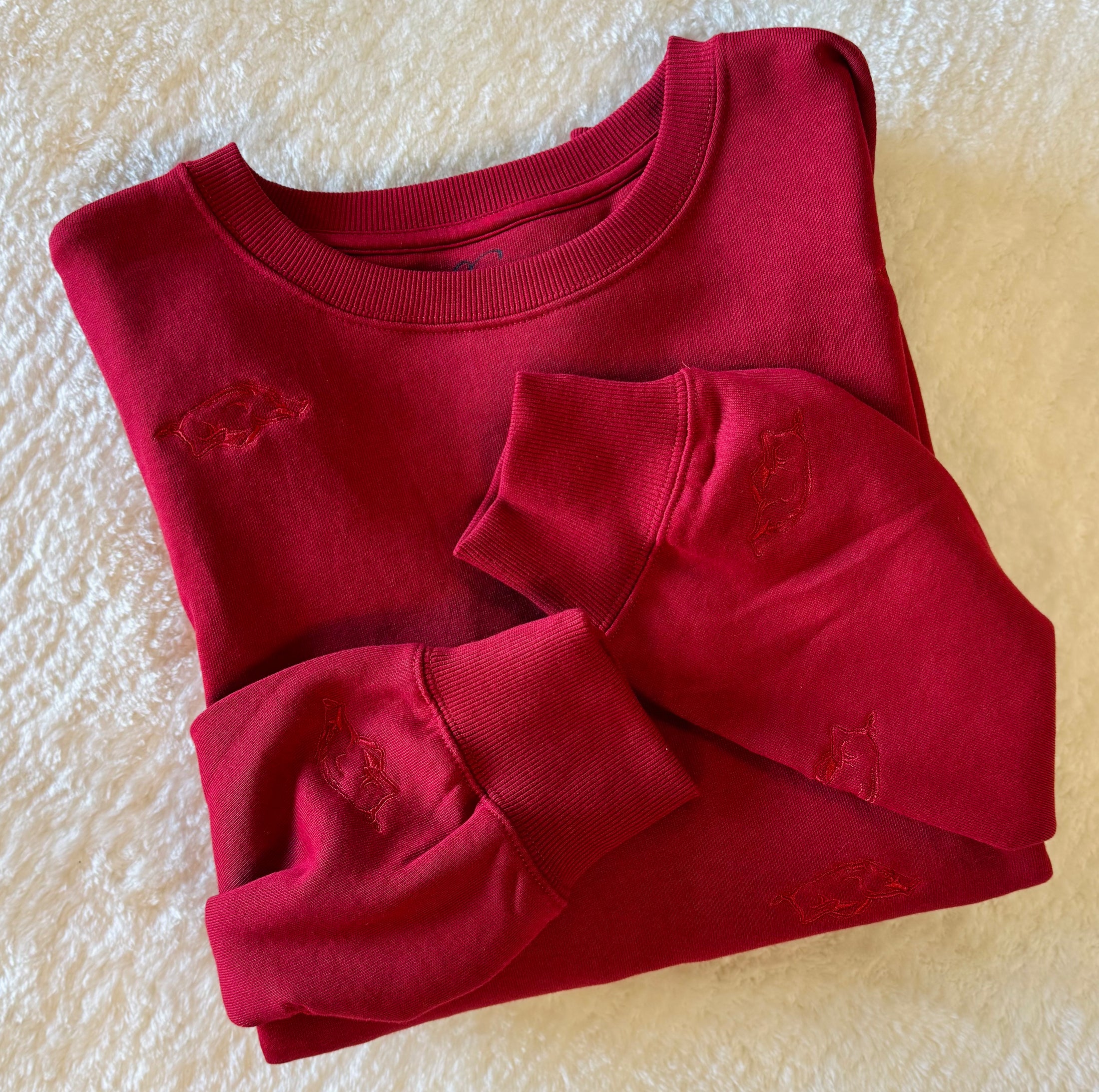 Folded red arkansas razorback sweatshirt in a Fayetteville, ar boutique store Arkansas Razorback sweatshirt for women, arkansas razorback store Fayetteville, ar, Arkansas boutique, Whimsy Boutique