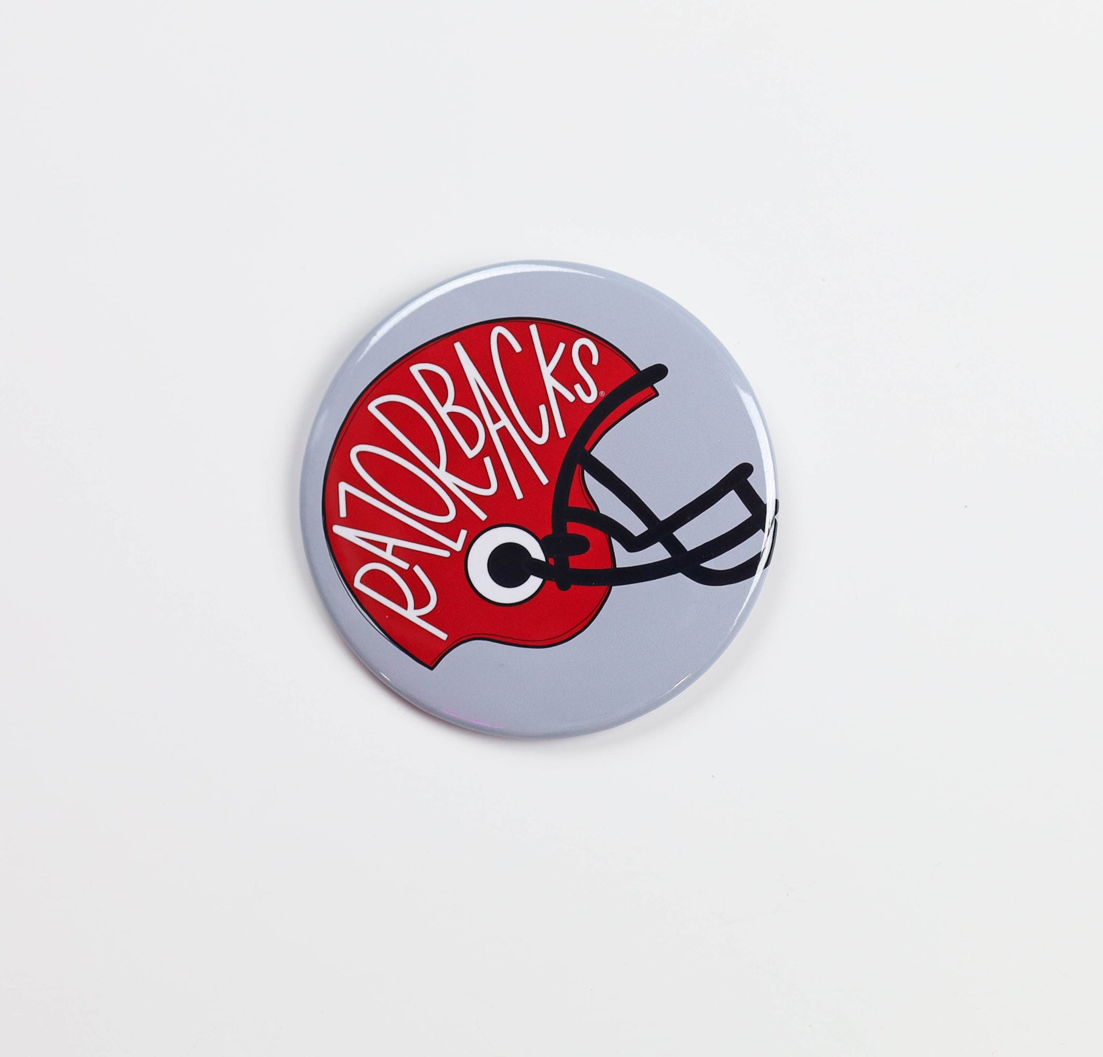 Button badge with 'Razorbacks' text and helmet design on a white background, razorback football helmet gameday pin, razorback football helmet gameday button, razorback gameday pin, razorback gameday button, razorback pin, razorback button, Arkansas pin, Arkansas button