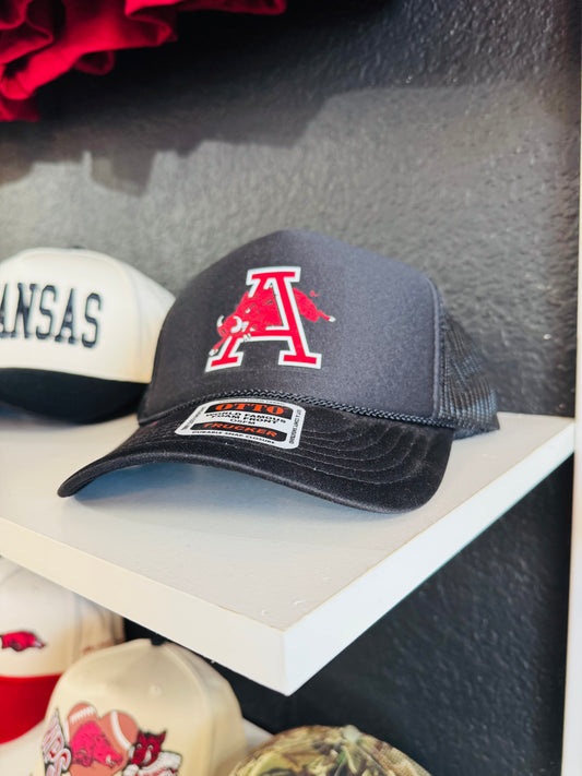 Black cap with red Arkansas Razorback logo on a shelf, razorback hat, hog hats, hats near me, razorback hats for sale, razorback hat patches, vintage Arkansas razorback hat, black razorback hat