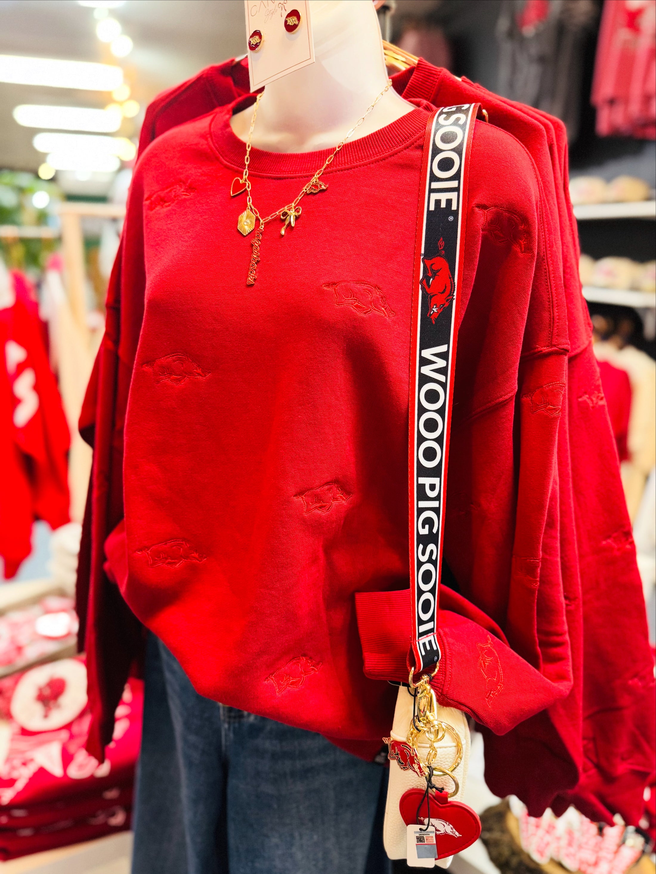 Mannequin wearing a red Arkansas razorback sweatshirt with a 'Woo! Pig Sooie' strap in a Fayetteville, ar store, Arkansas Razorback sweatshirt for women, arkansas razorback store Fayetteville, ar, Arkansas boutique, Whimsy Boutique